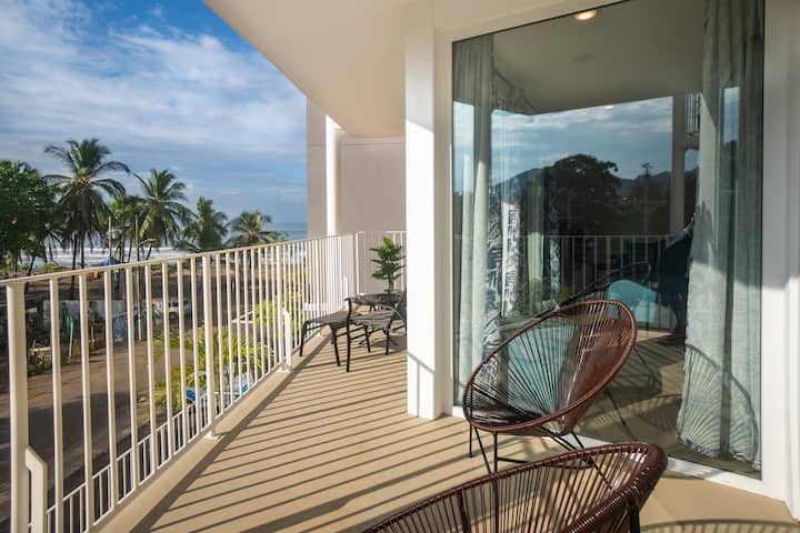 Balcony with Acapulco chairs and ocean view through palm trees