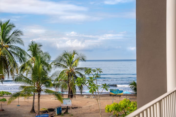 Ocean view from Casa Tica balcony with palm trees and Jaco beach